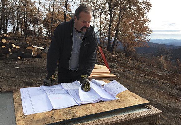 Gary Bazzani looking over architectural drawings on construction site